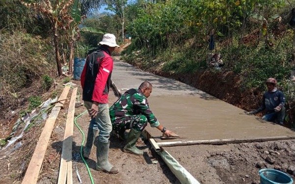 Gelorakan Semangat Karya Bakti, Serda Tato Babinsa Desa Wangun Jaya Melaksanakan Pengecoran Jalan Bersama Masyarakat