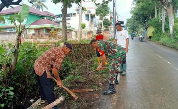 Babinsa Desa Sukajaya Lakukan Karya Bakti Pembersihan Jalan di Kampung Puncak Manis