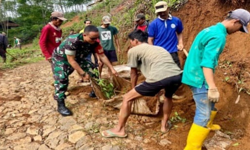 Babinsa Sukalaksana Gelar Karya Bakti Pembersihan Jalan Bersama Masyarakat