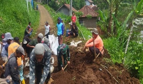 “Babinsa Desa Sukamekar Lakukan Karya Bakti Pembersihan Material Longsor”