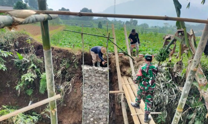 BANTU KESULITAN WARGA, BABINSA DESA CIBEUREUM LAKSANAKAN KARYA BAKTI PEMBANGUNAN JEMBATAN