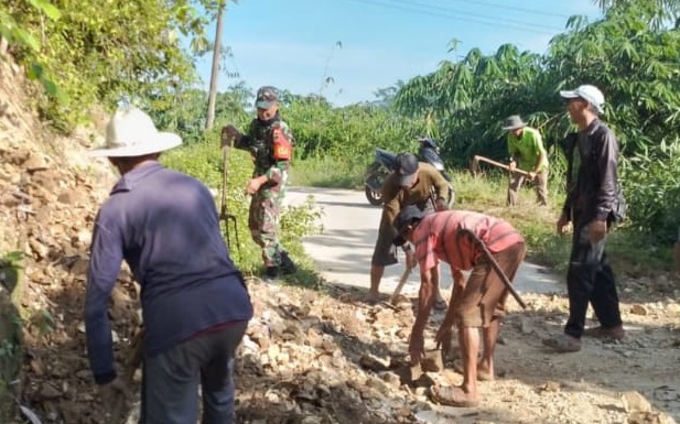 SERKA HERMAN BABINSA SINDANGSARI LAKSANAKAN KARYA BAKTI MEMPERBAIKI JALAN DESA