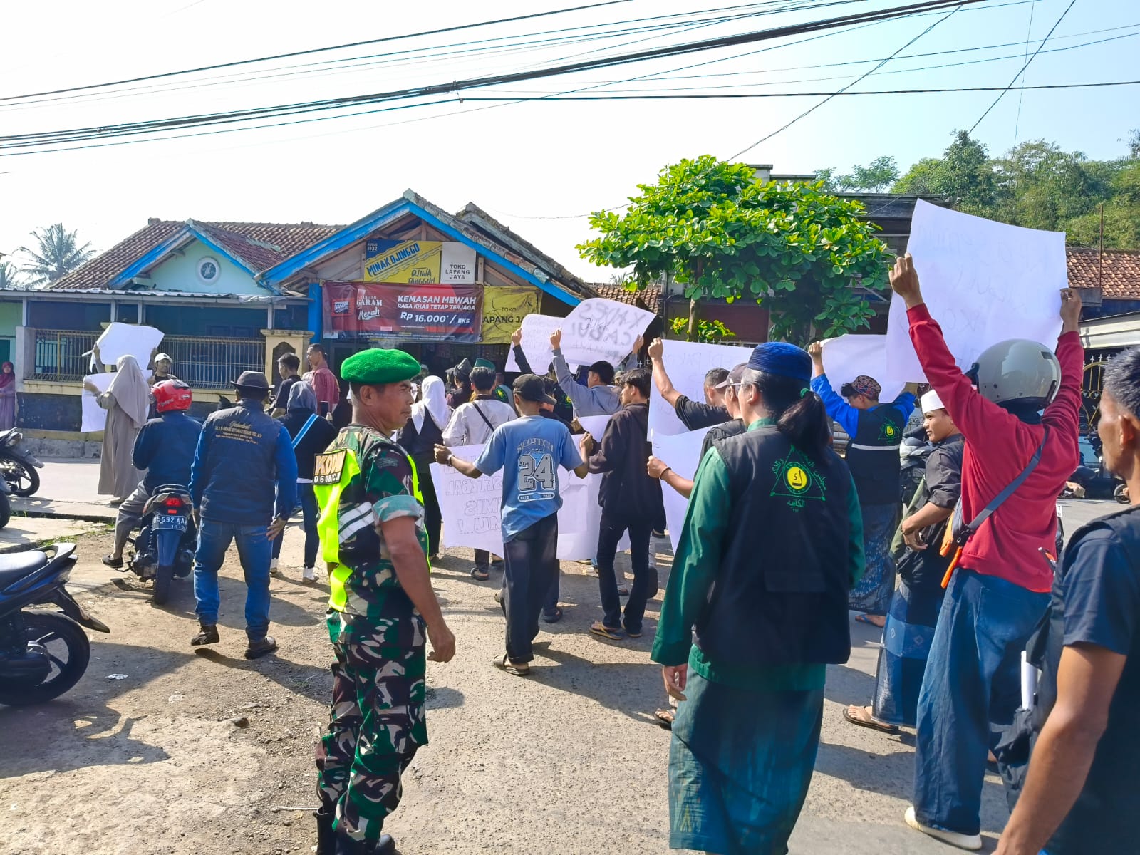 ANGGOTA KORAMIL 0608-03/CIBEBER LAKSANAKAN PENGAMANAN AKSI UNJUKRASA MASYARAKAT DI KANTOR DESA SUKARAHARJA