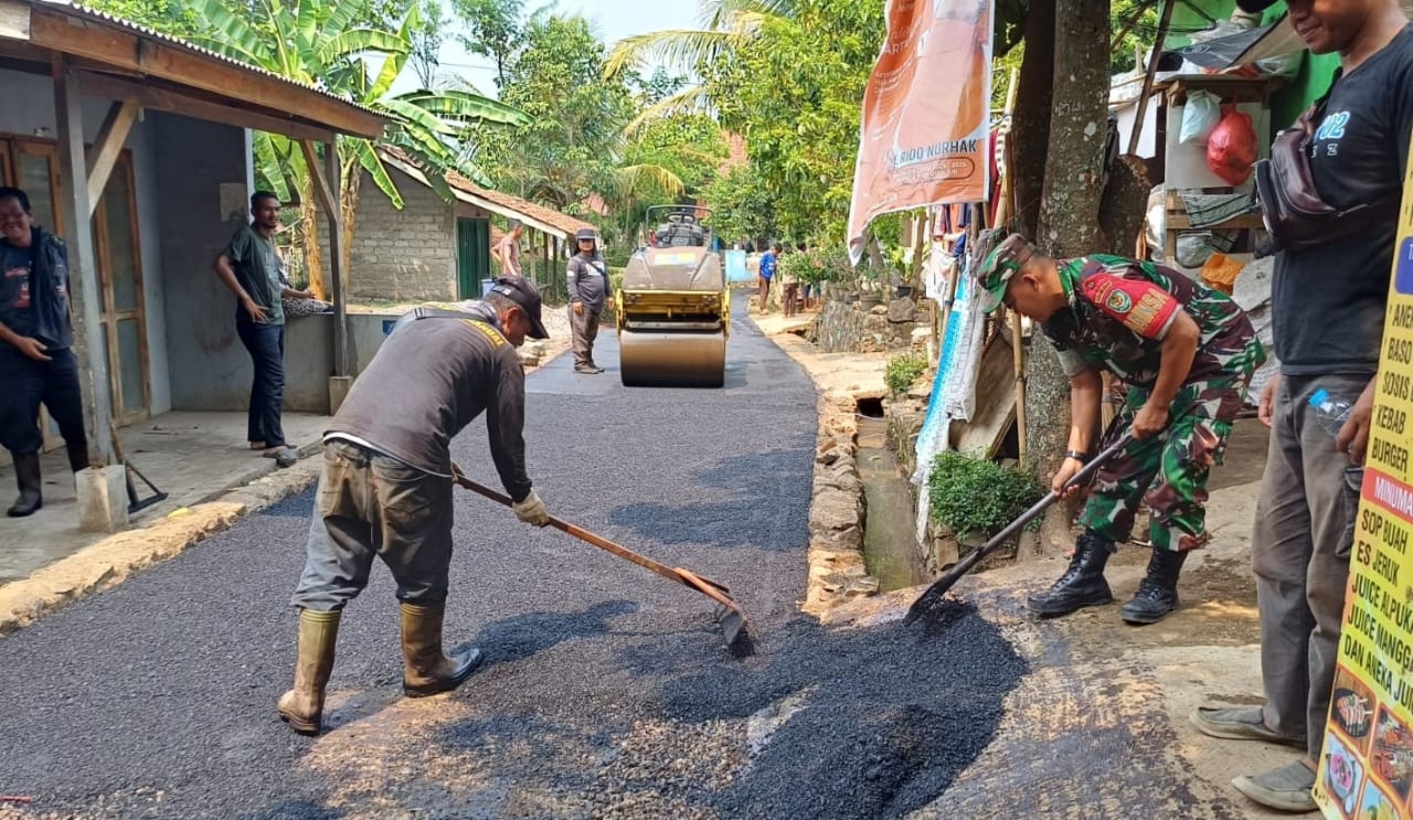 Semangat Gotong Royong: Babinsa Serda Syukri Pimpin Kerja Bakti Pengaspalan Jalan