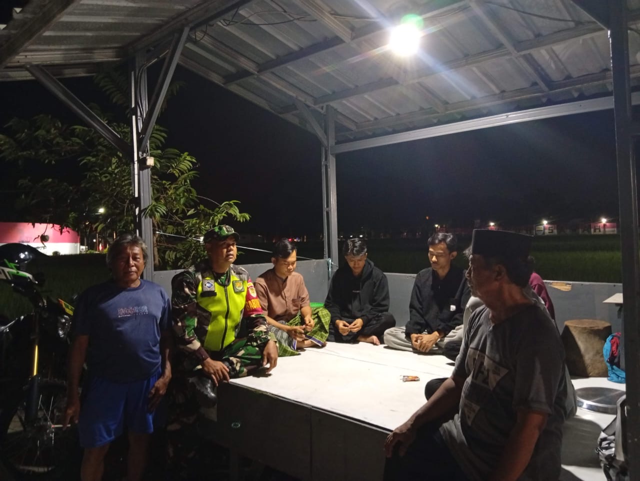 Tingkatkan Keamanan Lingkungan, Babinsa Sukasirna Gelar Monitoring Poskamling Malam Hari