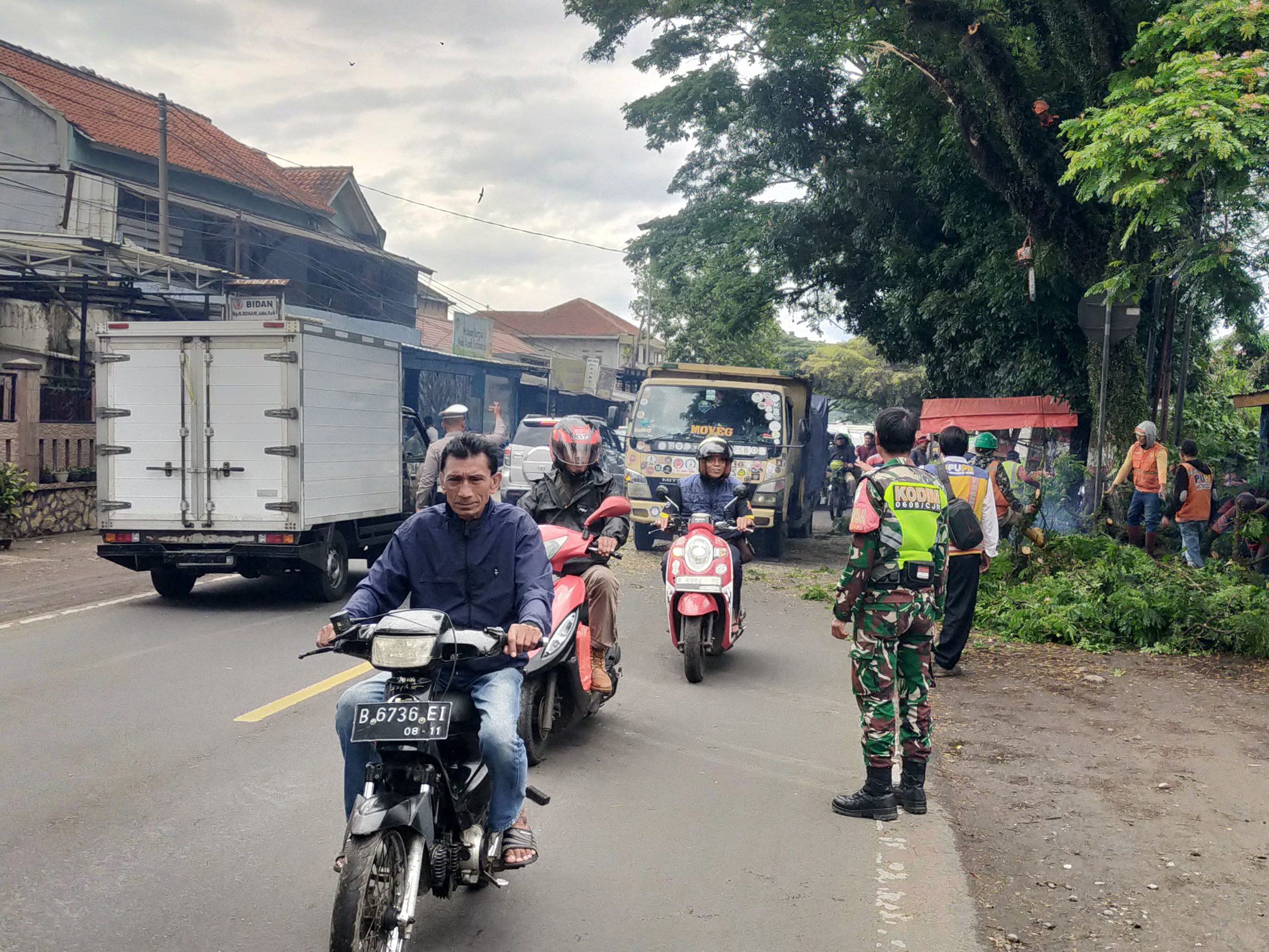 Pastikan Keselamatan Pengguna Jalan, Babinsa Cibiuk Amankan Proses Penebangan Pohon di Jalan Raya Bandung-Jakarta