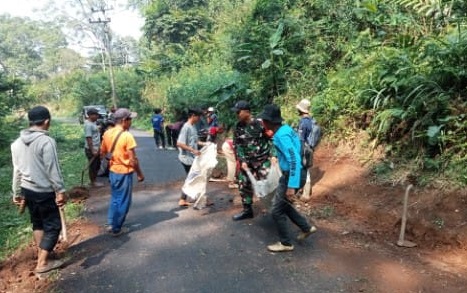 Babinsa Koramil Mande Gerakkan Gotong Royong, Bersihkan Jalan Desa Kutawaringin