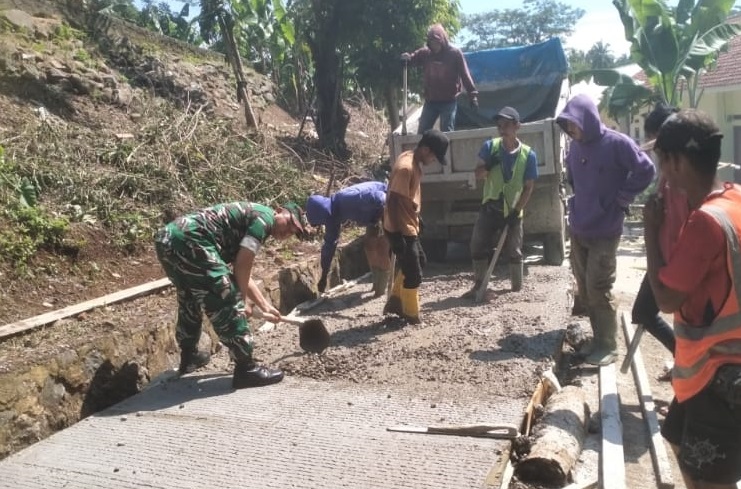 Wujud Kemanunggalan, Serda Surahmad Bahu-Membahu Bersama Warga Cor Jalan Desa
