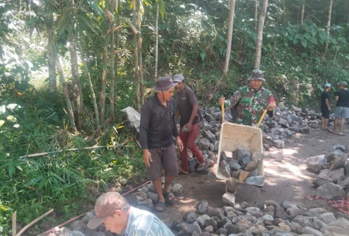 Tingkatkan Aksesibilitas Desa, Babinsa Serda Yogi S Bersama Warga Sukaraja Laksanakan Perkerasan Jalan