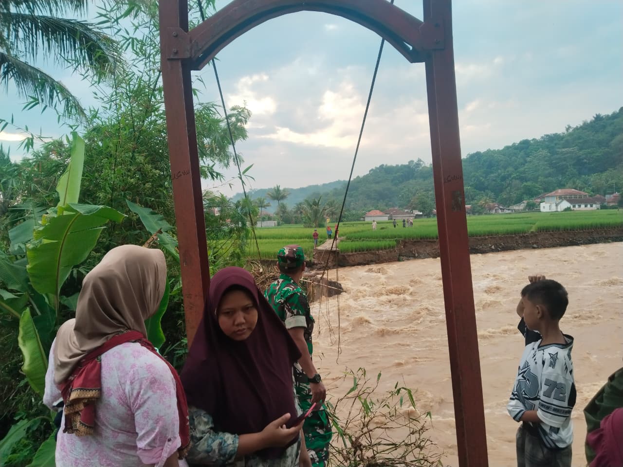 Akses Warga Terputus, Babinsa Desa Susukan Serka Endang Hidayat Pantau Jembatan Gantung yang Ambruk Diterjang Banjir