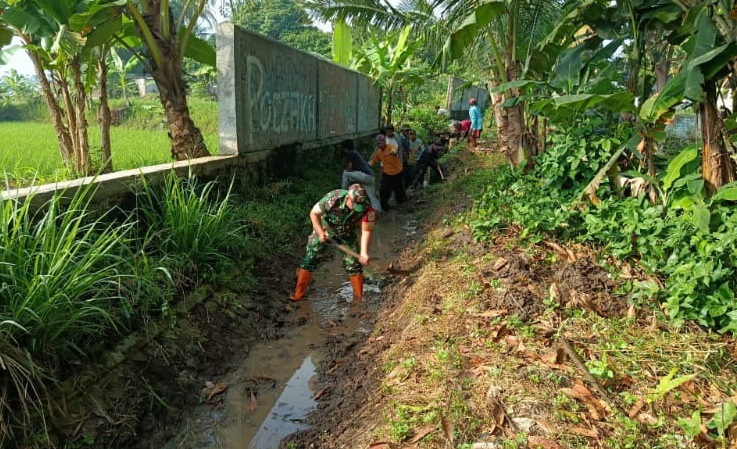 Dukung Ketahanan Pangan, Babinsa Desa Kertajaya Bersama Warga Bersihkan Saluran Irigasi Tersier